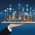 AllianzGI achieves rapid first close for real estate debt fund Smart city, building technology, and real estate business. Businessman holding digital tablet with buildings hologram and application programming interface technology