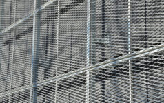 Closeup of wire mesh netting outside building.