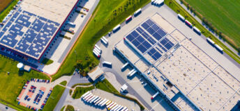Industry with low carbon footprint. Industrial warehouses with solar panels on the roof. Technology park and factories from above