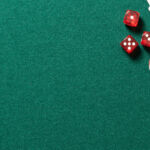 Poker table in casino top view. Green table with poker chips, cards and dices, background with copy space.