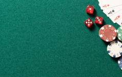 Poker table in casino top view. Green table with poker chips, cards and dices, background with copy space.