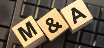 Image of blocks spelling out M&A, representing mergers and acquisitions.