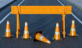 Under construction traffic cones and orange barrier road boundary.