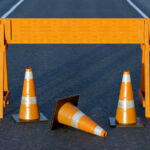 Under construction traffic cones and orange barrier road boundary.