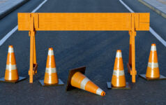 Under construction traffic cones and orange barrier road boundary.