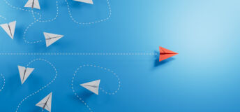 Paper planes, white flying randomlly but for one in red flying with purpose