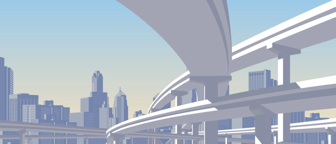 Photo of a highway overpass with a city skyline in the back.