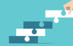 Graphic of a hand placing a puzzle piece into one piece that is connected to another piece, connecting to another.