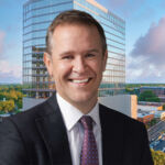 Peter Gordon, head and chief investment officer, US commercial real estate debt, at AllianceBernstein in front of an image of 110 East Boulevard in Charlotte, North Carolina.