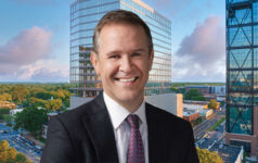 Peter Gordon, head and chief investment officer, US commercial real estate debt, at AllianceBernstein in front of an image of 110 East Boulevard in Charlotte, North Carolina.