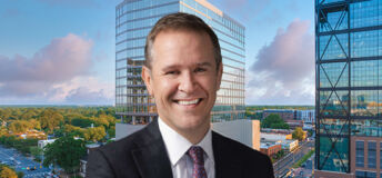 Peter Gordon, head and chief investment officer, US commercial real estate debt, at AllianceBernstein in front of an image of 110 East Boulevard in Charlotte, North Carolina.
