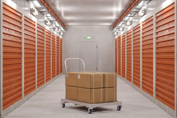 Self Storage Units And Close-up Of Hand Truck With Cardboard Boxes In Corridor Self Storage Units And Close-up Of Hand Truck With Cardboard Boxes In Corridor
