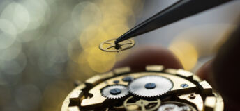 Pocket watch being repaired by senior watch maker, close-up. Black and white.