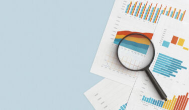 Brookfield closes buy of $890m loan portfolio from Sunflower Bank Business graphs, charts and magnifying glass on table