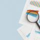 Brookfield closes buy of $890m loan portfolio from Sunflower Bank Business graphs, charts and magnifying glass on table