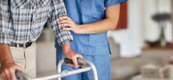 Shot of a woman assisting her elderly patient who's using a walker for support