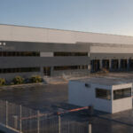 A photo of a large industrial building and it's accompanying car park