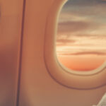 Woman in the window seat of a plane looking out