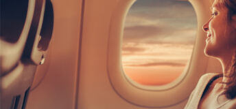 Woman in the window seat of a plane looking out