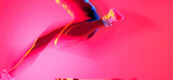 A female athlete jumps over a hurdle