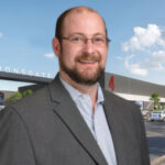 Mike Doty, senior director of originations at Nuveen Green Capital, in front of a rendering of Great Point Studios' Newark development in New Jersey.