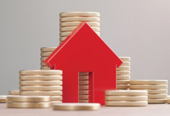 Five key trends driving change in private real estate credit Image of a block house next to stacks of coins.